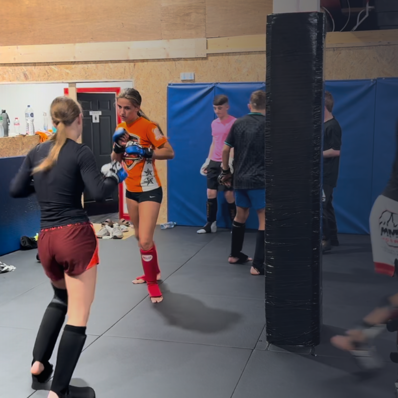 Beginners practicing MMA drills in pairs at MMA Cork, focusing on movement and technique."